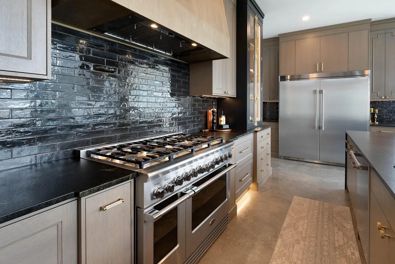 The kitchen’s glossy tile backsplash, professional-style range and built-in stainless fridge