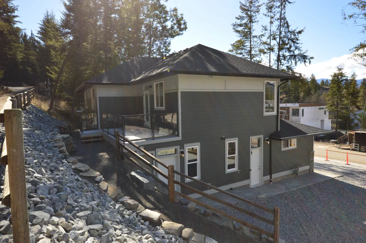 The home’s lower side, with its covered deck above a slope of landscaped rock