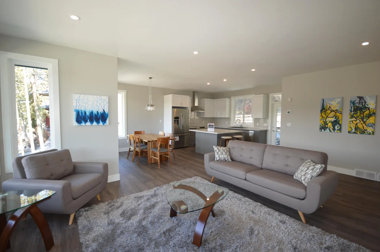 The open main floor, with the living room, dining table and kitchen beyond