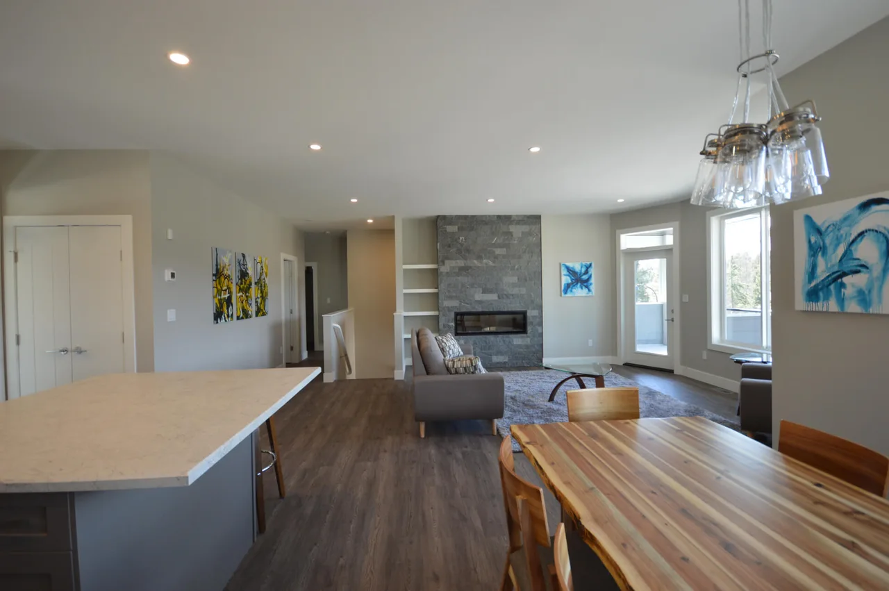 The dining area between the kitchen island and the stone fireplace