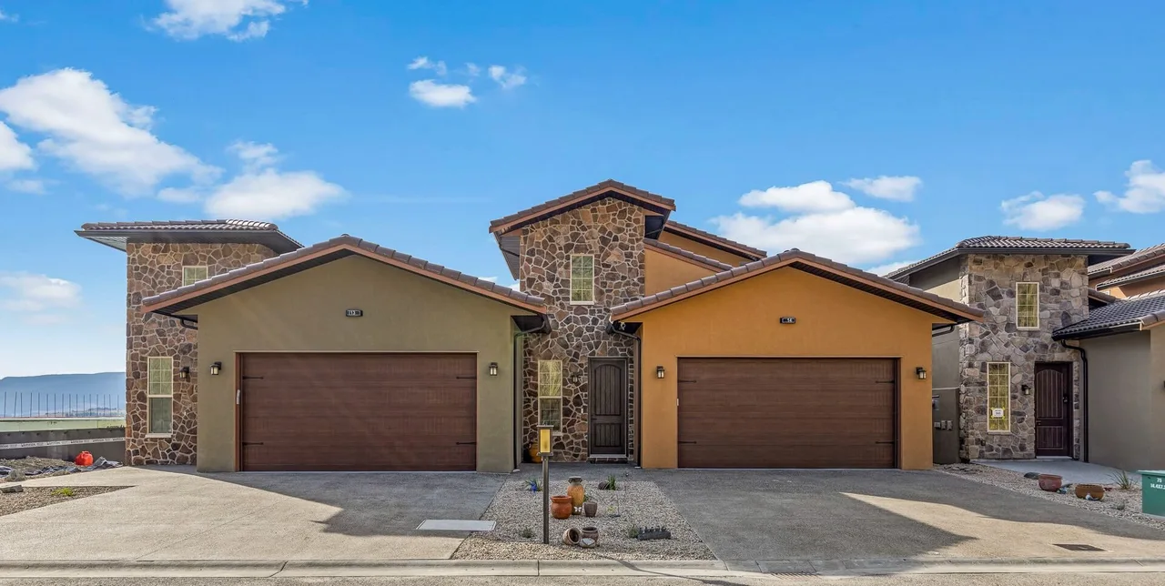 The front of a Vineyard Way duplex: stucco, cultured stone, clay tile roofs and two garages