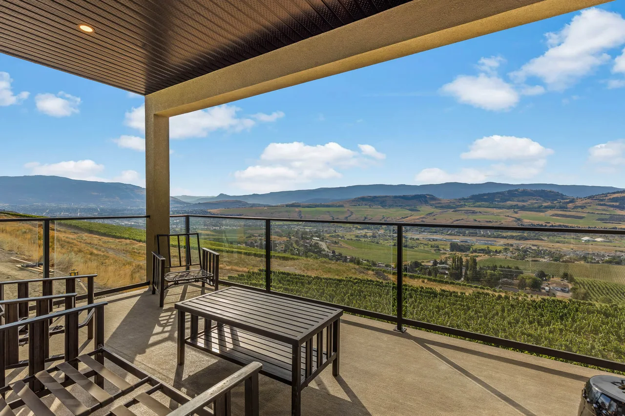 A covered patio with outdoor seating overlooking the valley and the vineyard