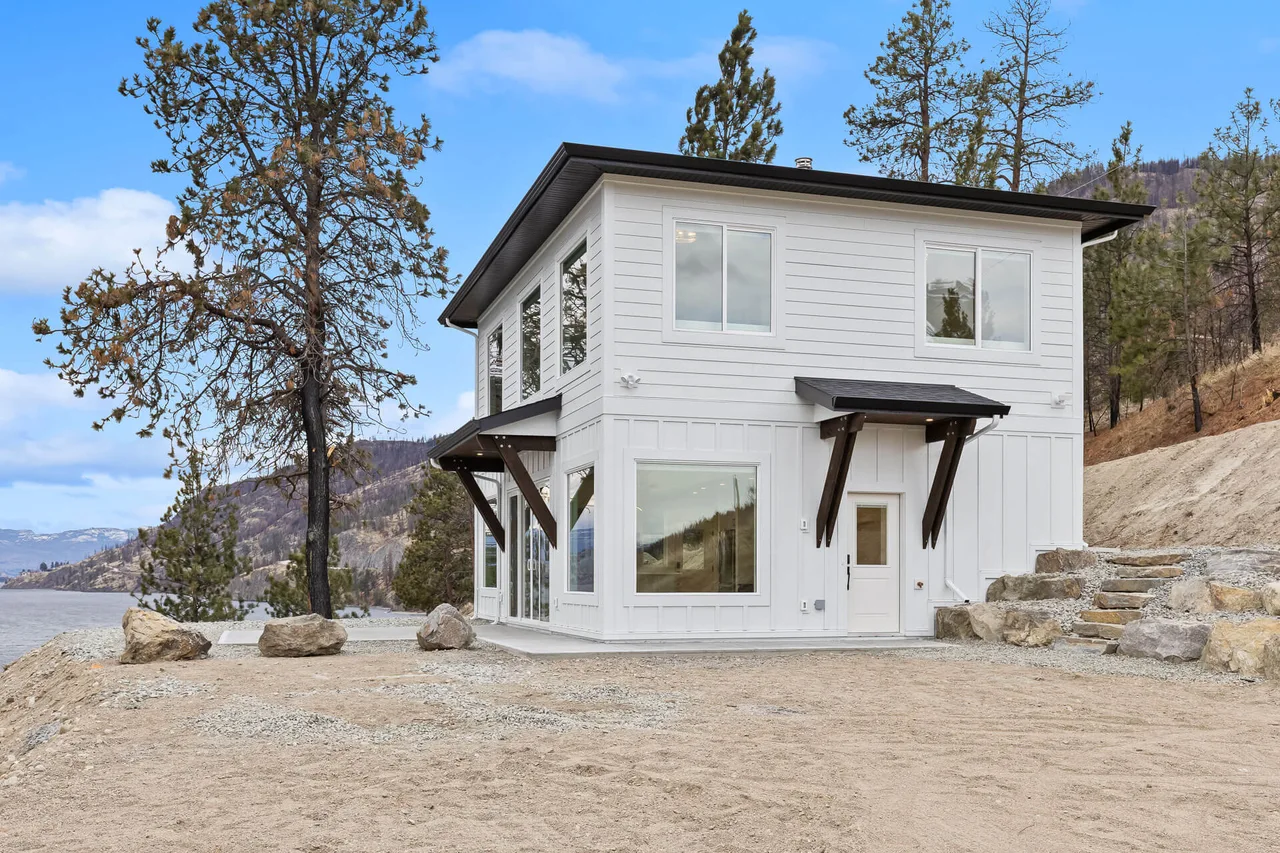 Browse Road: a white carriage house with board and batten siding among the pines above Okanagan Lake