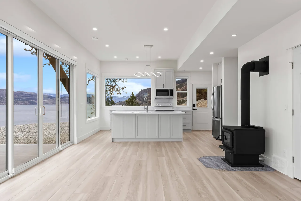 The kitchen and living area, with a freestanding wood stove and sliding doors onto the lake