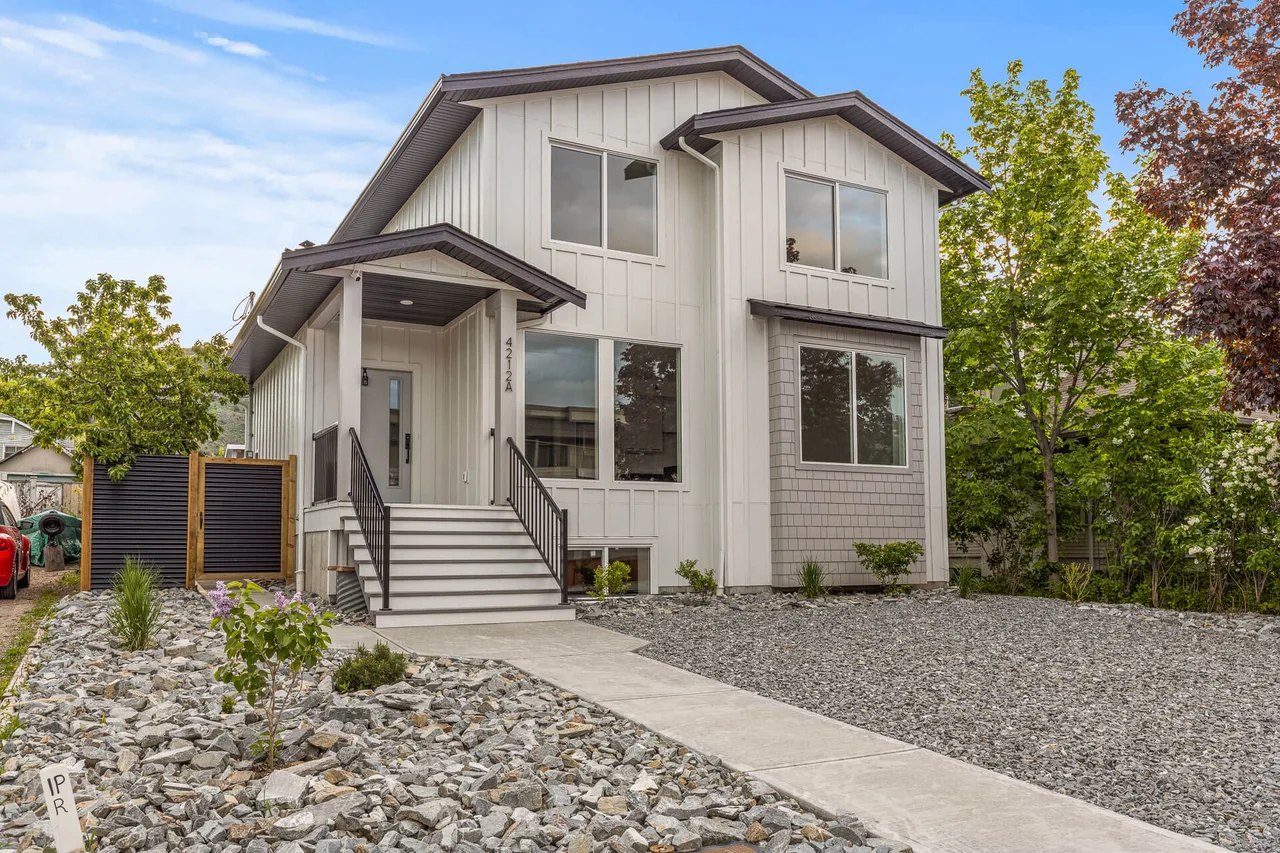 33rd Street from the street: a two-storey home with board and batten siding and a covered front entry