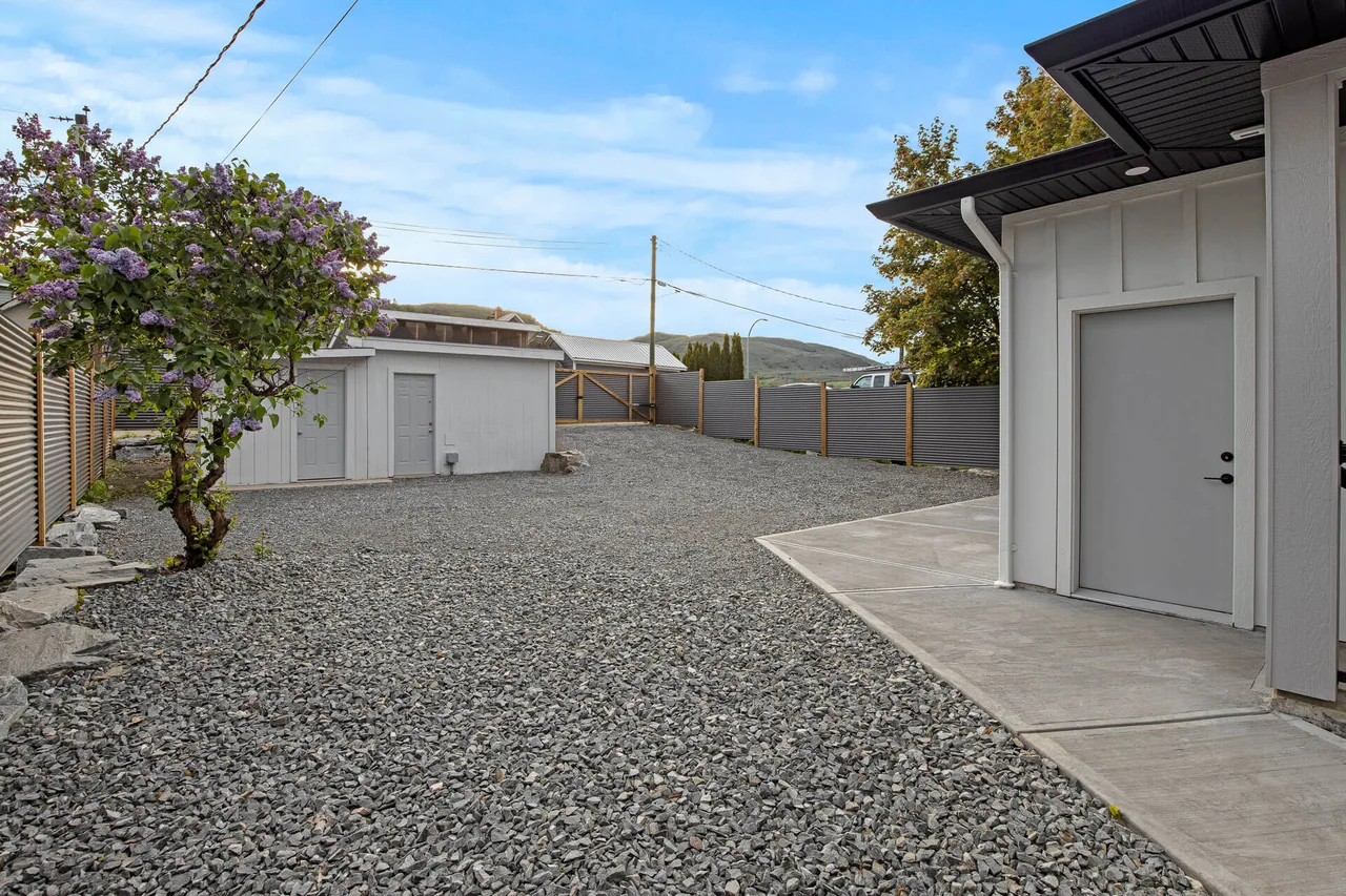 The back of the home, with a gravel yard and a double garage
