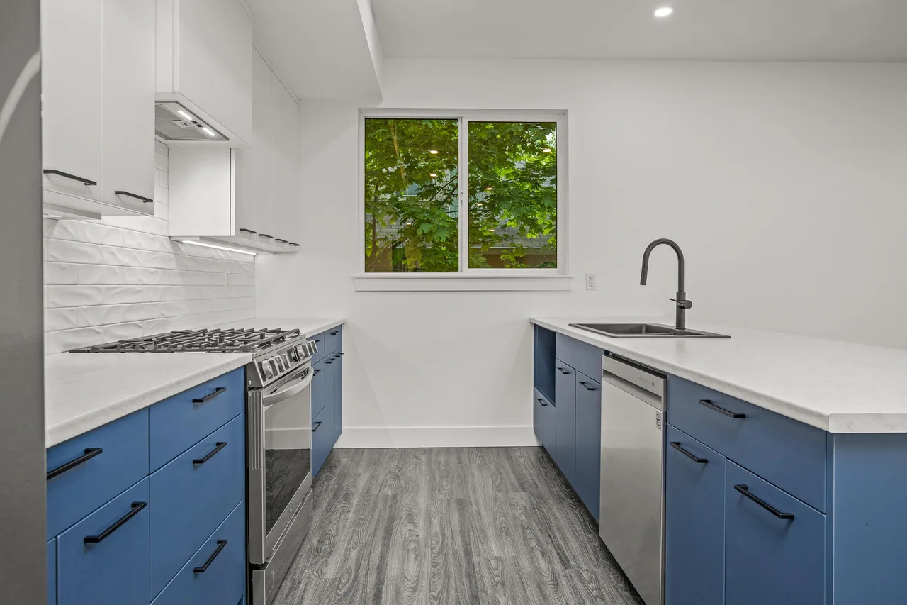 The kitchen’s navy cabinets, white quartz and gas range