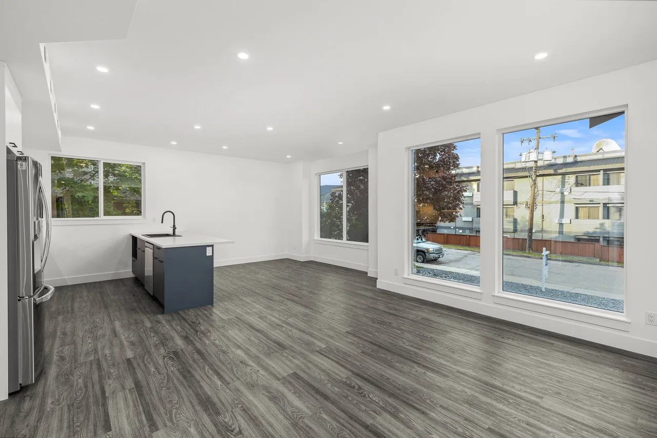 The open main floor, with the kitchen and living area and large windows